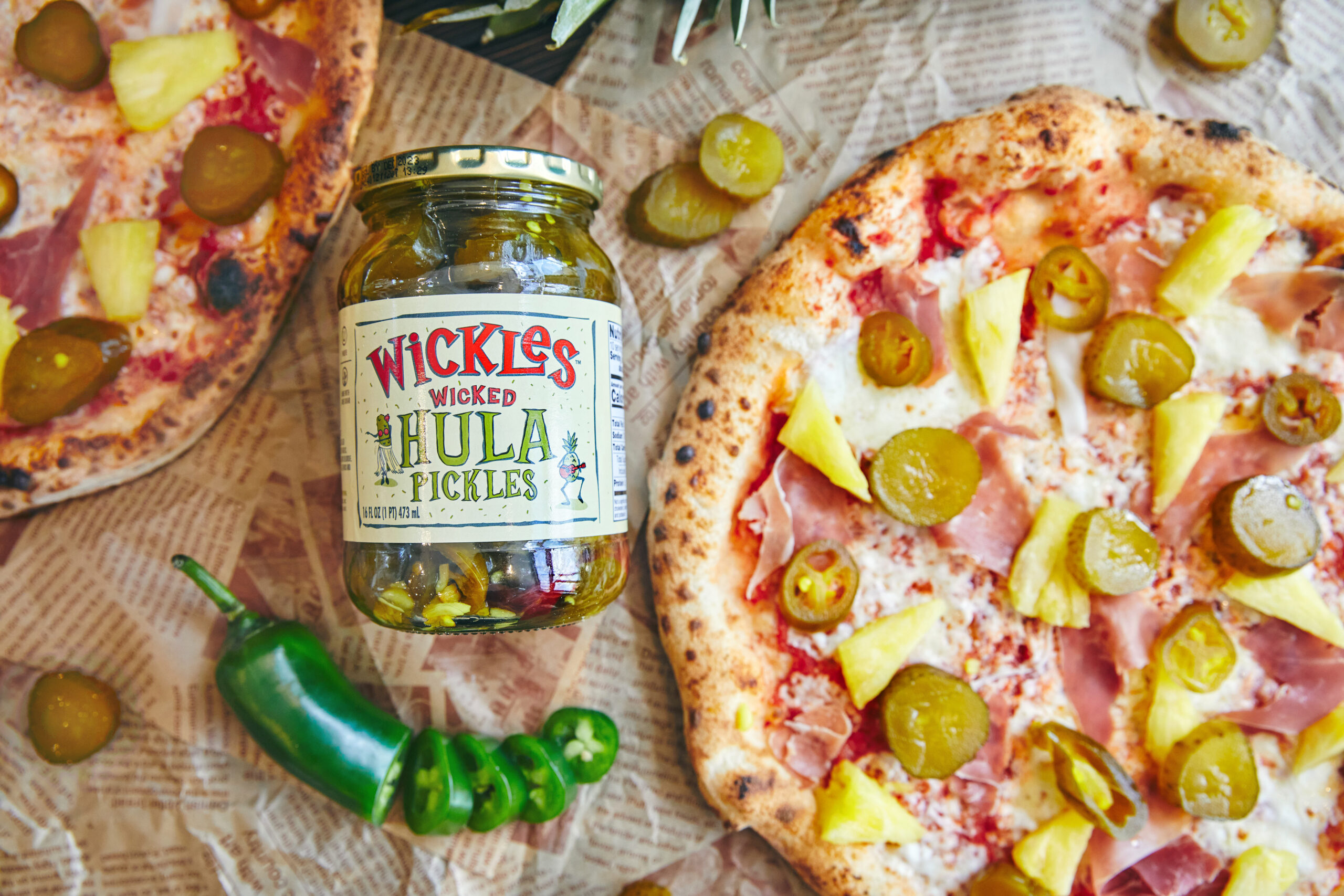 Wickles Hula Pizza with sliced jalapeno and jar of Wickles Hula Pickles beside it